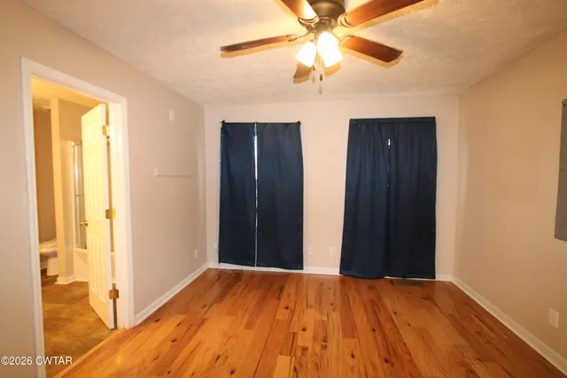 a view of a backyard with large trees and plants