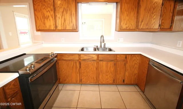a kitchen with a sink a stove and cabinets
