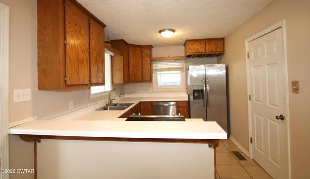 a kitchen with stainless steel appliances granite countertop a sink and a refrigerator