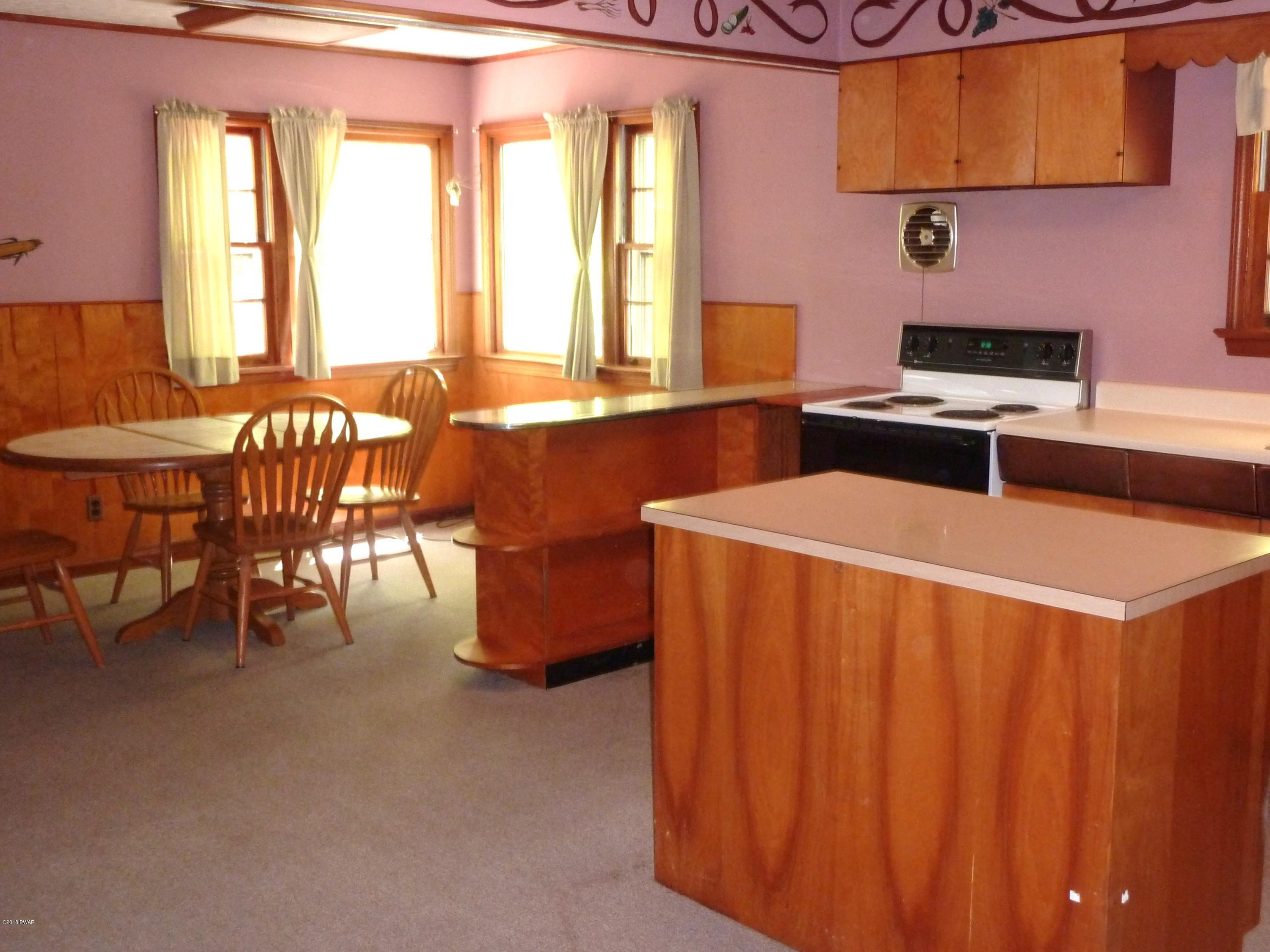 27 E Road Hawley, PA 18428 - Photo 3 of 22 a kitchen with stainless steel appliances a stove a sink a dining table and chairs
