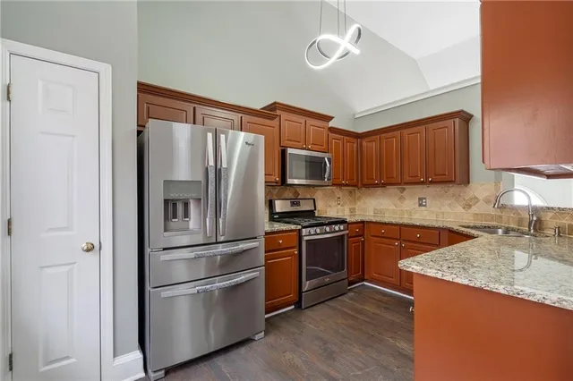 a kitchen with granite countertop stainless steel appliances and wooden cabinets