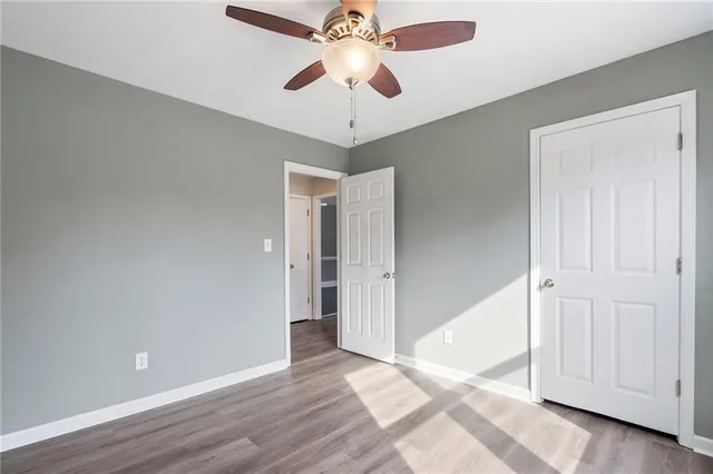a view of an empty room and chandelier fan