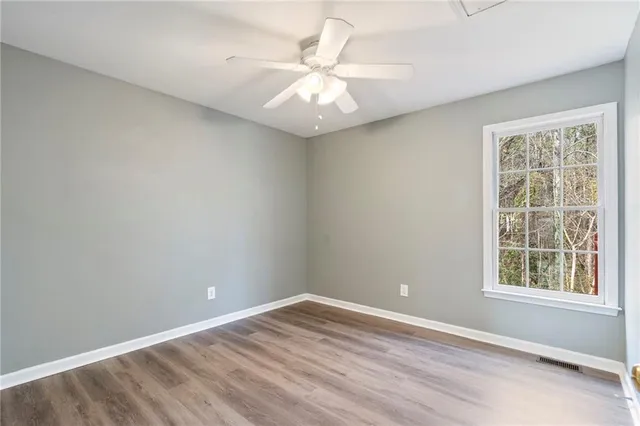 an empty room with a window and a fan