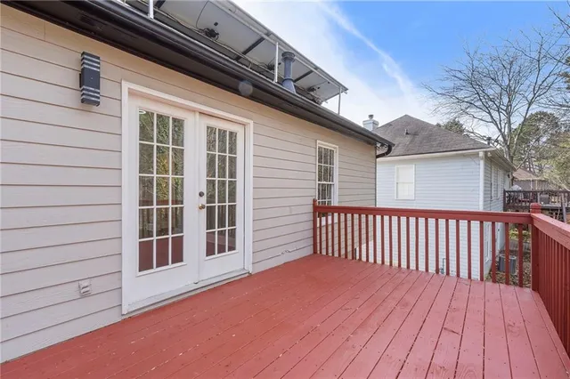 an empty room with wooden floor chandelier and windows