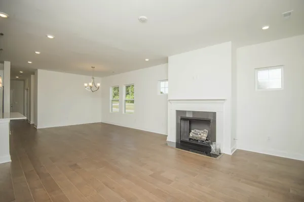 an empty room with windows and fireplace