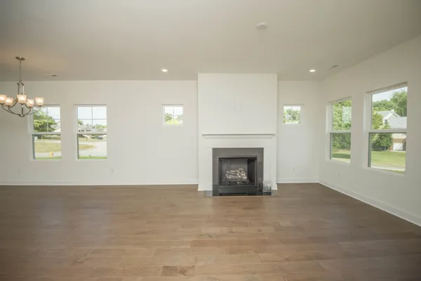 an empty room with windows and fireplace