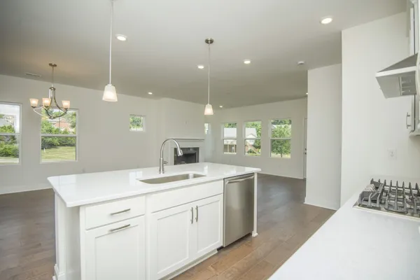 a kitchen with stainless steel appliances granite countertop a sink a stove and a refrigerator