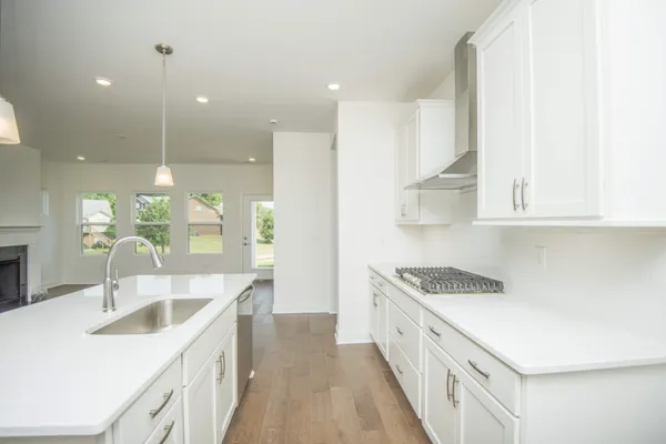 a kitchen with white cabinets a sink and a stove