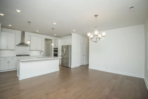 an empty room with windows and chandelier