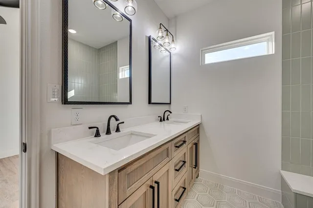 a bathroom with double sink and two mirror