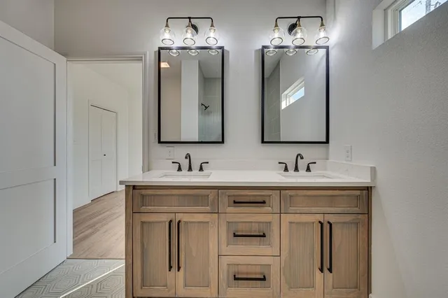 a bathroom with double sink and two mirror