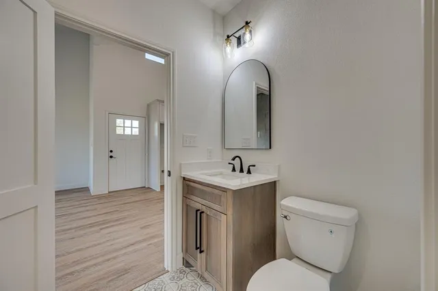 a bathroom with a toilet a sink and mirror