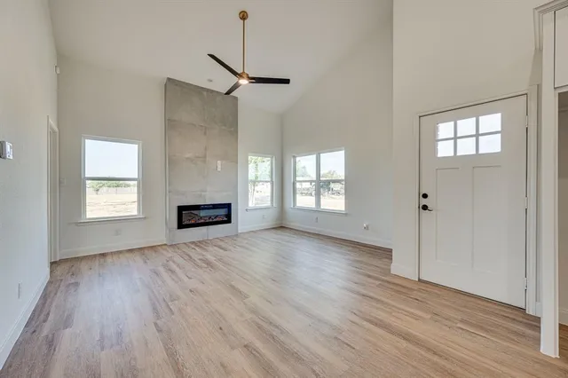 a view of an empty room with a window and wooden floor