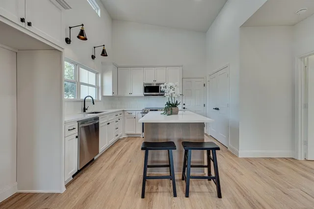 a kitchen with a table chairs refrigerator and window