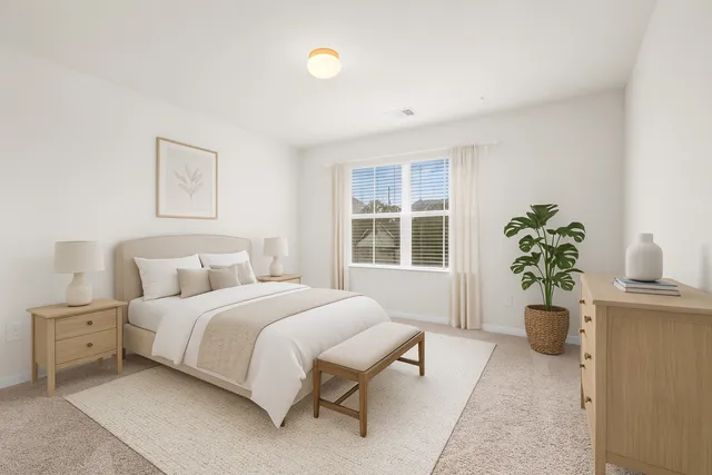 a bedroom with a bed and a potted plant