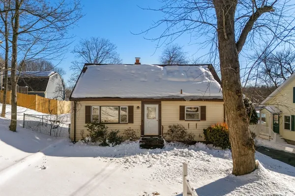 a front view of house with yard and trees around