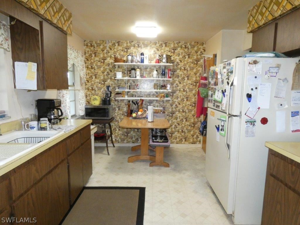 18555 Geranium Road Fort Myers, FL 33967 - Photo 5 of 25 a kitchen with refrigerator and cabinets