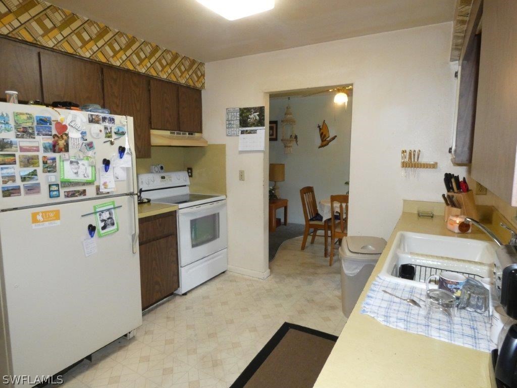 18555 Geranium Road Fort Myers, FL 33967 - Photo 6 of 25 a kitchen with stainless steel appliances granite countertop a sink stove and refrigerator