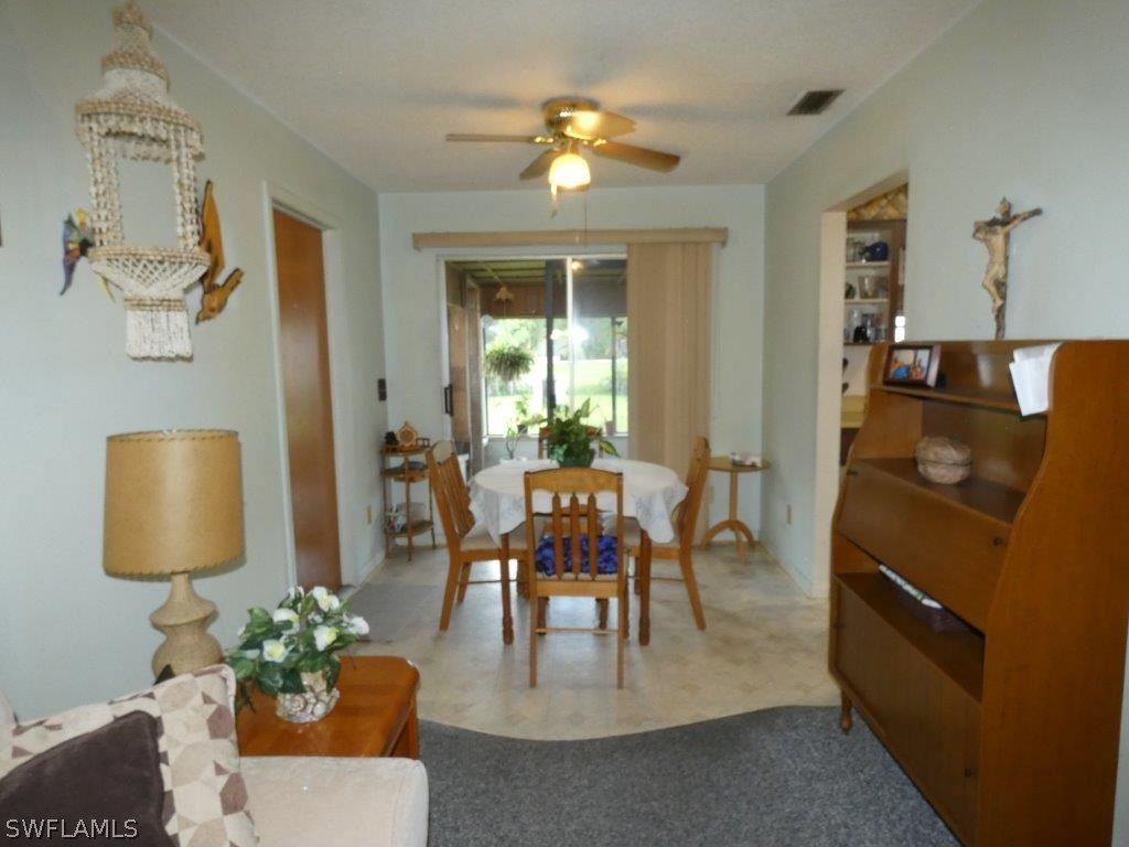 18555 Geranium Road Fort Myers, FL 33967 - Photo 8 of 25 a dining room with furniture a potted plant and a chandelier
