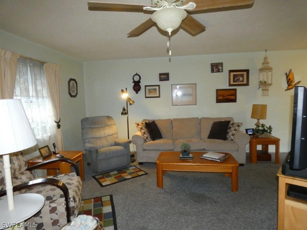 18555 Geranium Road Fort Myers, FL 33967 - Photo 10 of 25 a living room with furniture a chandelier and a dining table