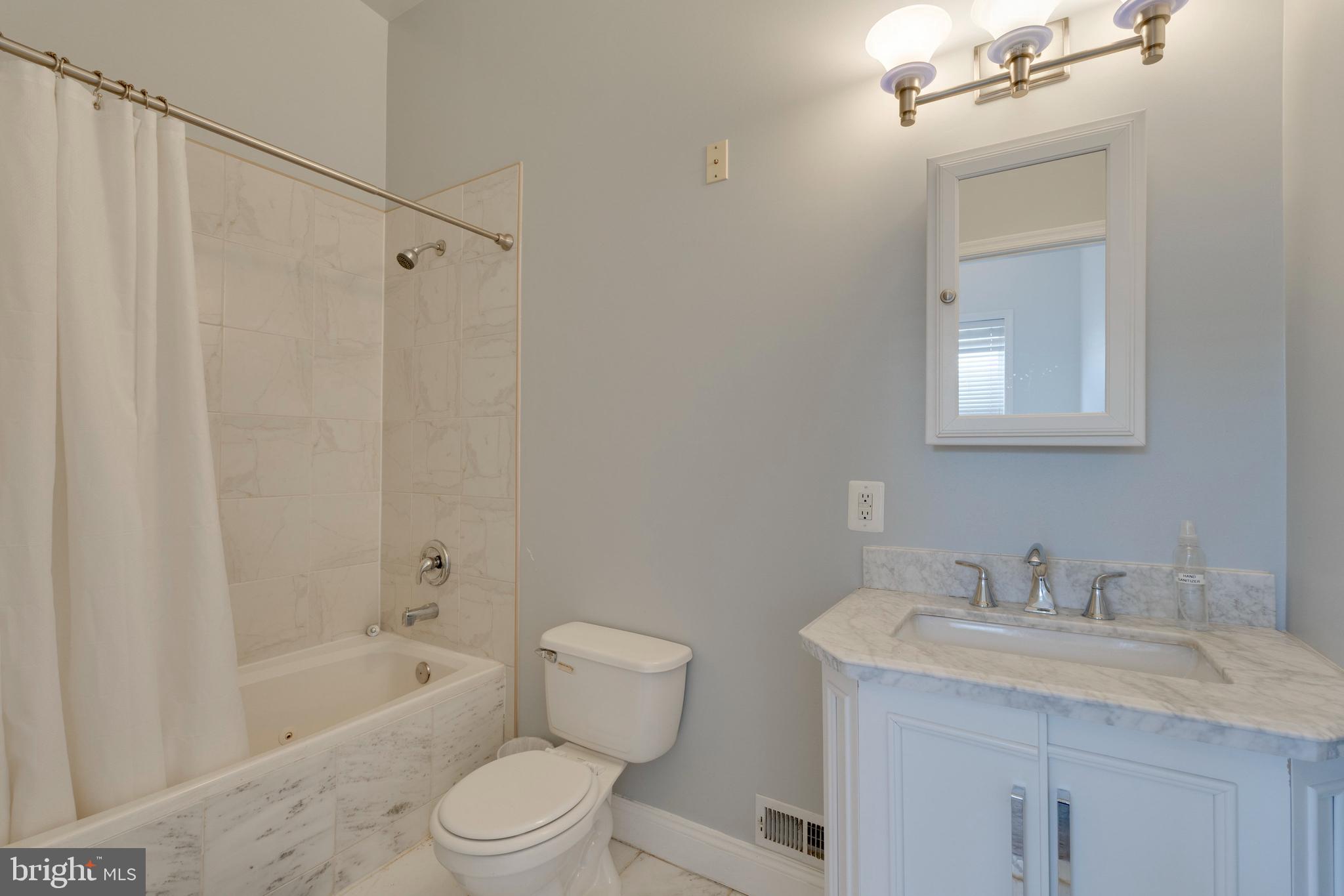 3017 Warder Street Northwest Washington, DC 20001 - Photo 13 of 14 a bathroom with a granite countertop sink toilet a shower and a mirror
