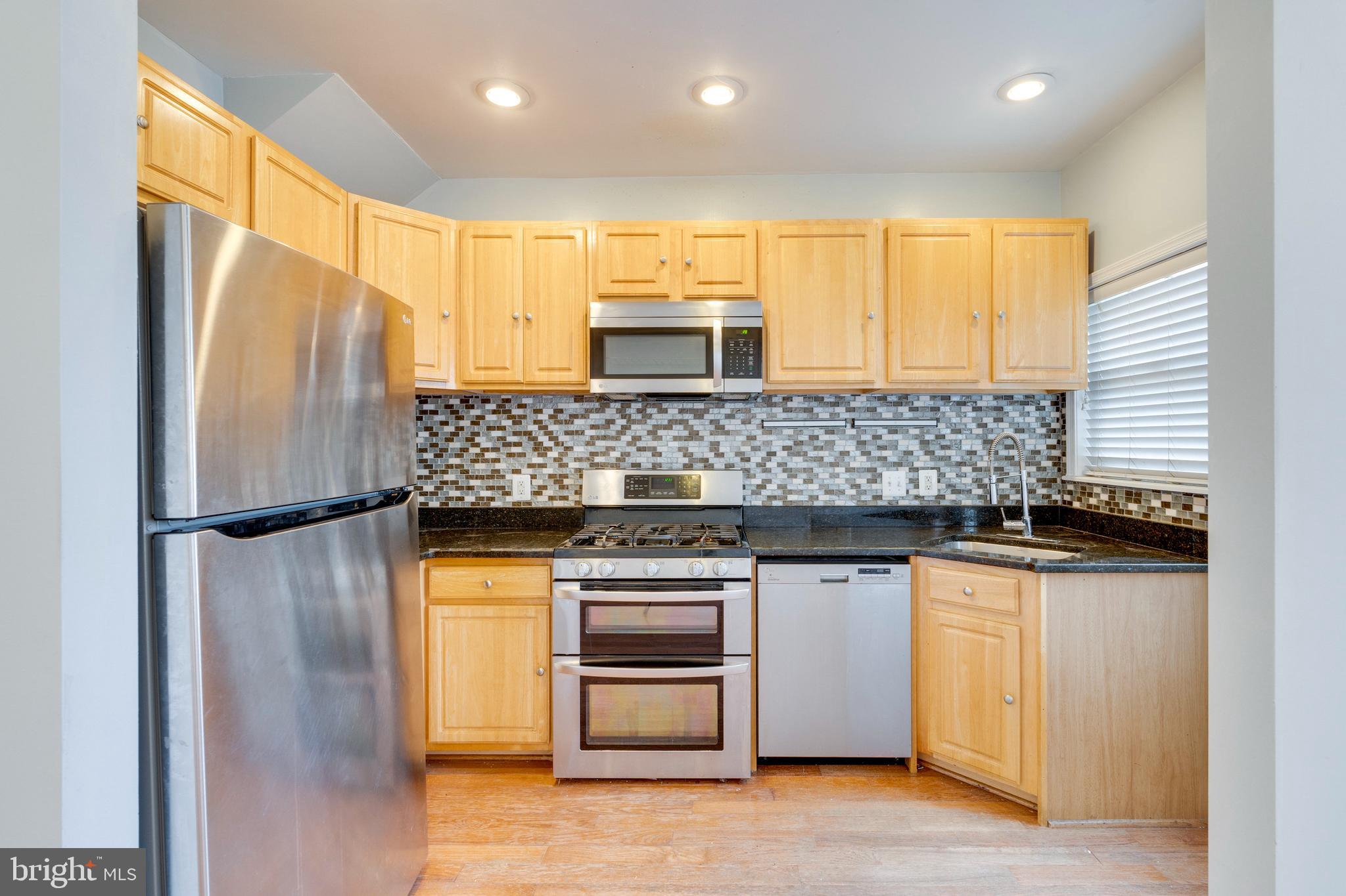 3017 Warder Street Northwest Washington, DC 20001 - Photo 5 of 14 a kitchen with stainless steel appliances granite countertop a refrigerator a stove and a sink