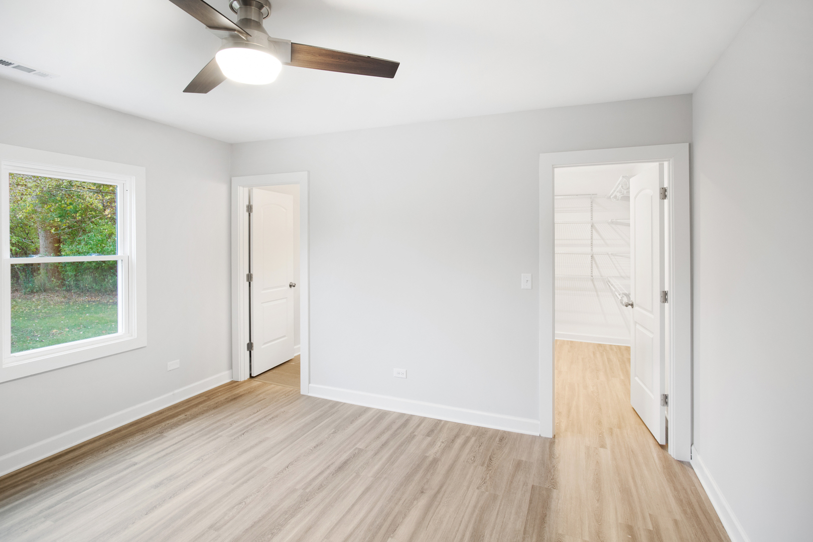 715 Anthony Trail Northbrook, IL 60062 - Photo 7 of 20 an empty room with wooden floor cabinet and windows