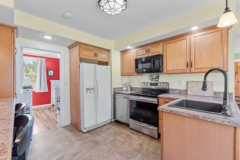 250 Brookside Road Orange, MA 01364 - Photo 14 of 30 a kitchen with granite countertop a stove top oven sink and refrigerator