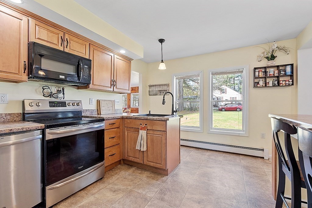 250 Brookside Road Orange, MA 01364 - Photo 15 of 30 a kitchen with stainless steel appliances granite countertop a stove a sink and a microwave