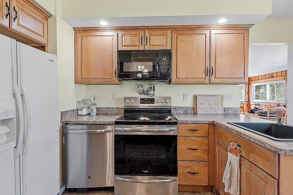 250 Brookside Road Orange, MA 01364 - Photo 17 of 30 a kitchen with stainless steel appliances granite countertop a stove a sink and a microwave