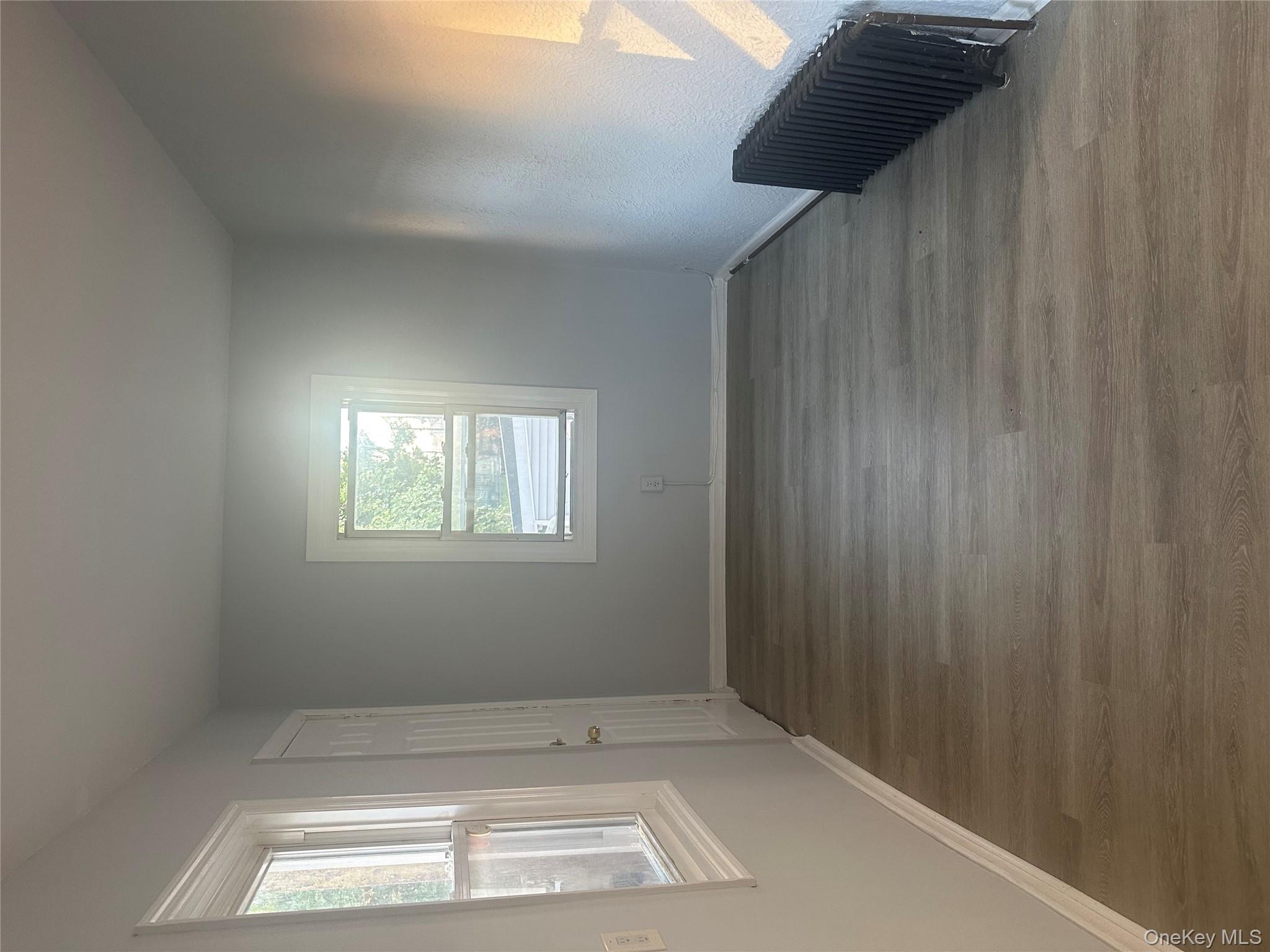 4 Ritters Lane Yonkers, NY 10703 - Photo 15 of 41 a view of an empty room with wooden floor and a window