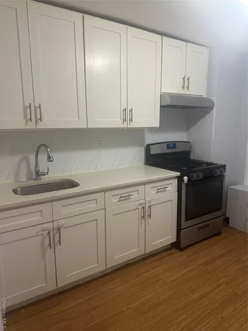 an empty room with wooden floor and door