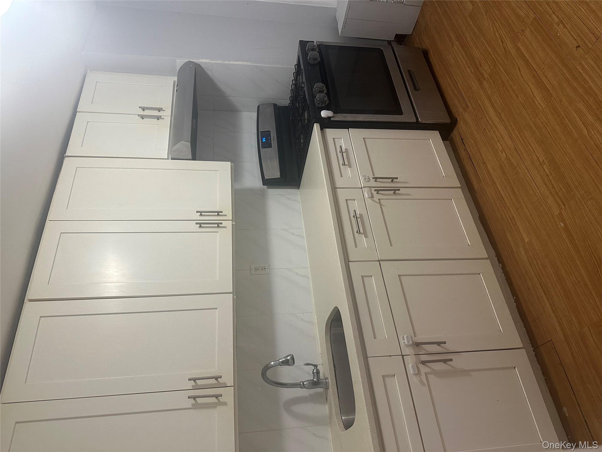 4 Ritters Lane Yonkers, NY 10703 - Photo 32 of 41 a kitchen with granite countertop white cabinets and a stove