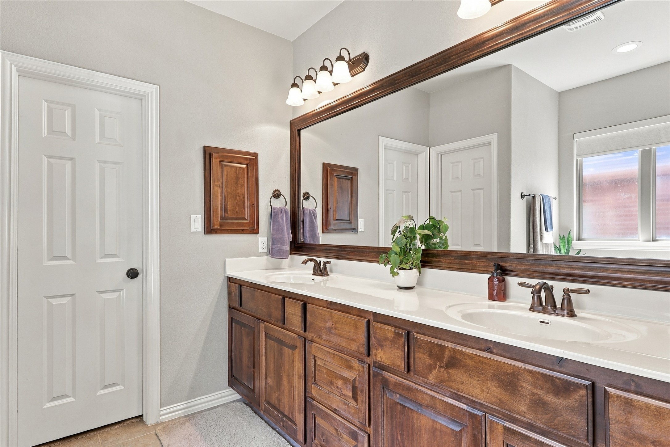 320 Fort Cobb Way Georgetown, TX 78628 - Photo 13 of 37 A spacious double vanity features rich wood cabinetry under a broad, framed mirror.