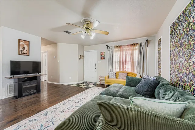 a backyard of a house with wooden fence and large trees