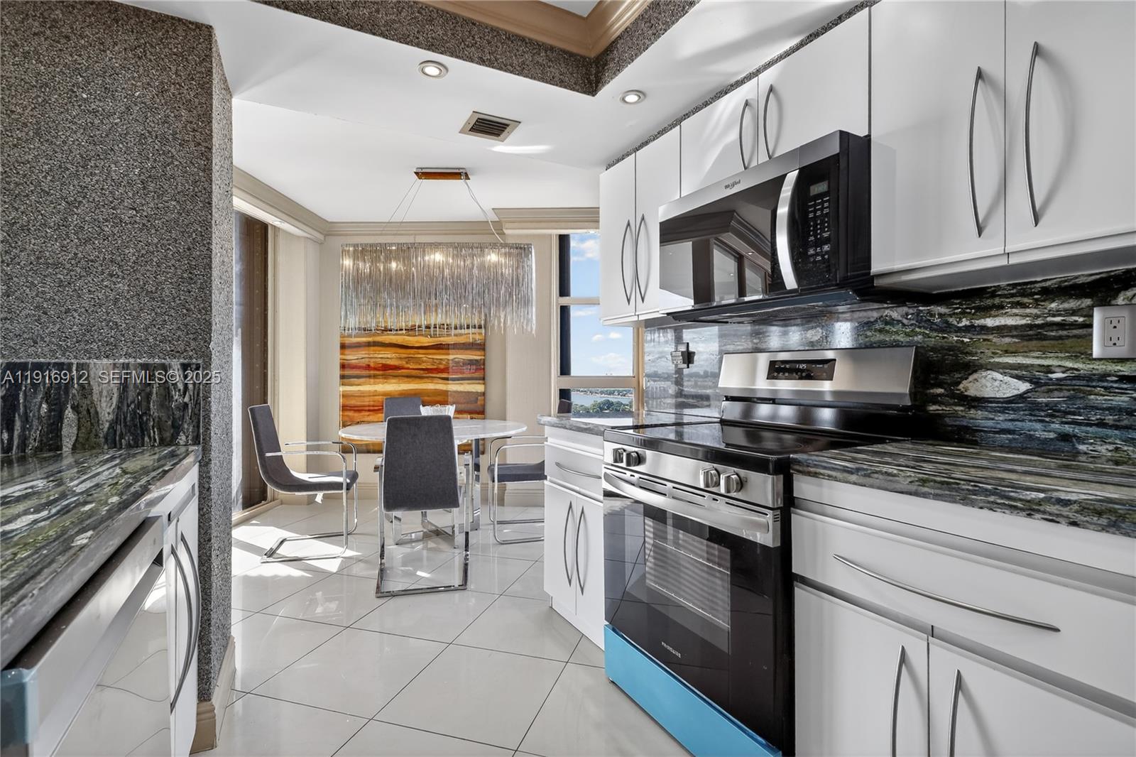 4000 Towerside Terrace, Unit 1612 Miami, FL 33138 - Photo 11 of 49 a kitchen with stainless steel appliances granite countertop a stove top oven a sink and a microwave