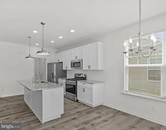 a kitchen with stainless steel appliances kitchen island granite countertop a sink stove and cabinets