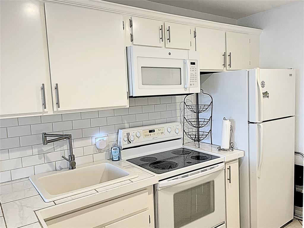 1655 Cedar Crest Loop, Unit A1 Graford, TX 76449 - Photo 7 of 15 a kitchen with white cabinets and white appliances