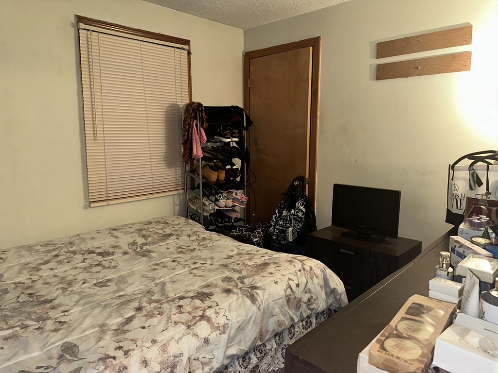 25-27 Merida Street Springfield, MA 01104 - Photo 4 of 20 a bedroom with a bed and a chair