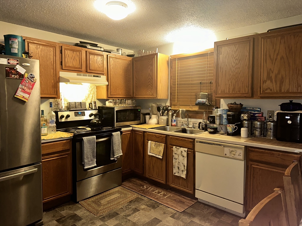 25-27 Merida Street Springfield, MA 01104 - Photo 5 of 20 a kitchen with stainless steel appliances a sink cabinets and a window