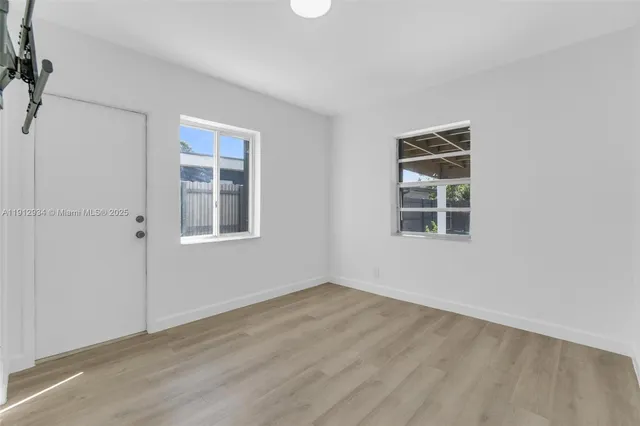 a view of an empty room with wooden floor