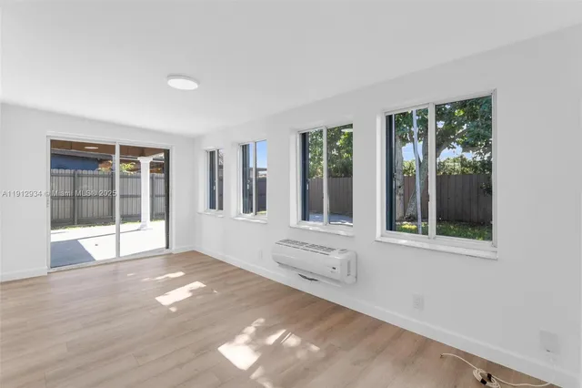 a view of empty room with wooden floor and windows