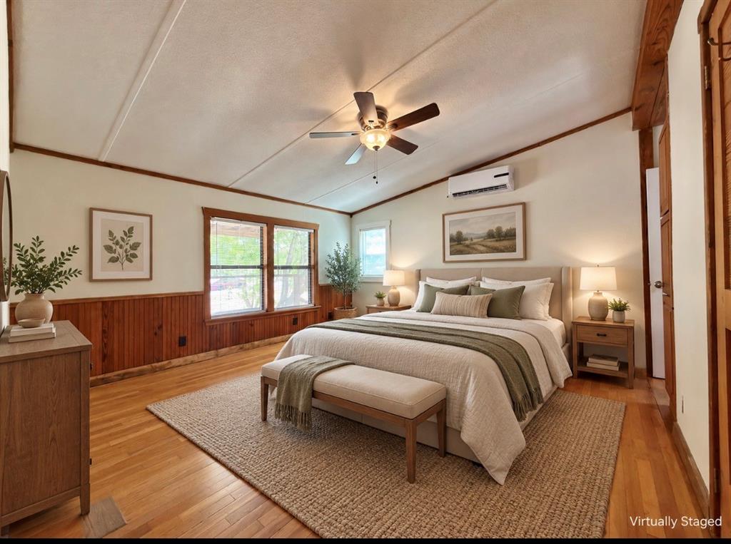4676 Old Dallas Road Elm Mott, TX 76640 - Photo 10 of 21 Vaulted ceiling, paneled accent wall, hardwood flooring, ceiling fan, and large windows
