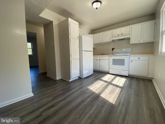 a kitchen with granite countertop white cabinets and white appliances