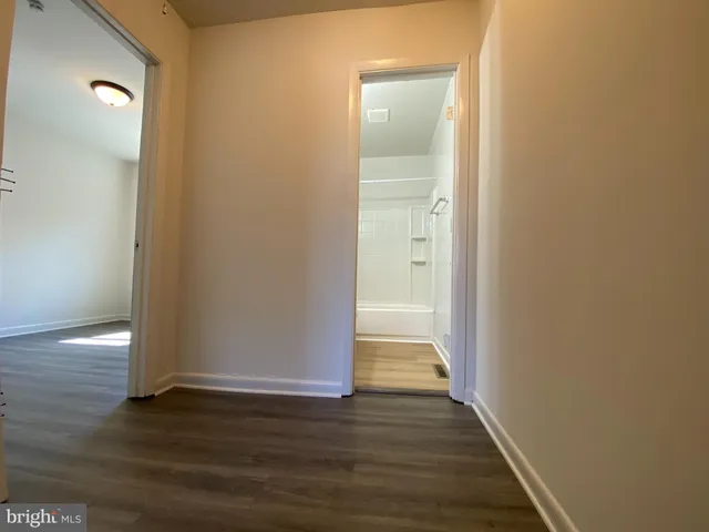 a view of an empty room with wooden floor