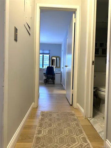 a bedroom with a bed a desk and chair with wooden floor