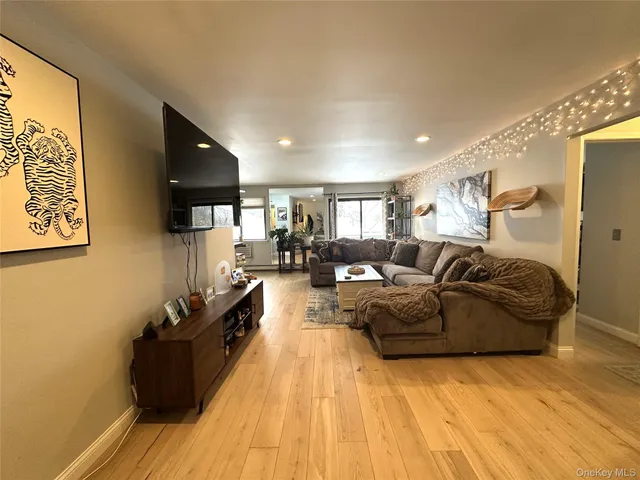 a kitchen with stainless steel appliances kitchen island granite countertop a stove a sink and a refrigerator with wooden floor