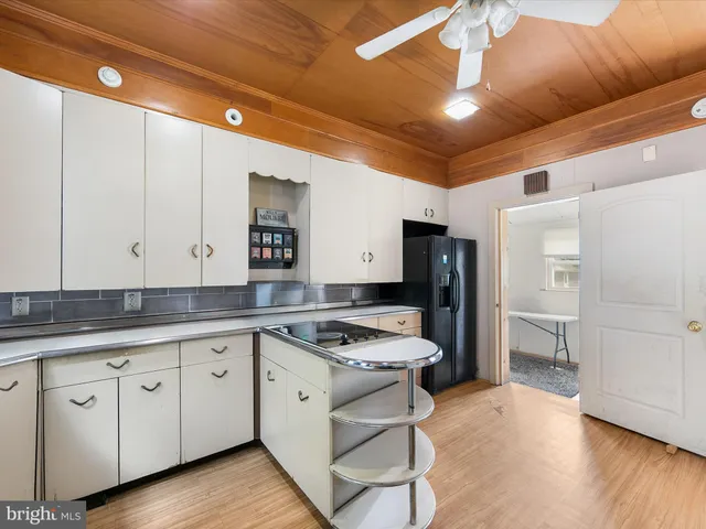 a kitchen that has a lot of cabinets in it and wooden floors