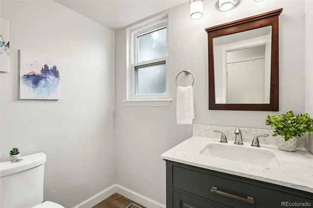 a bathroom with a granite countertop sink mirror and toilet