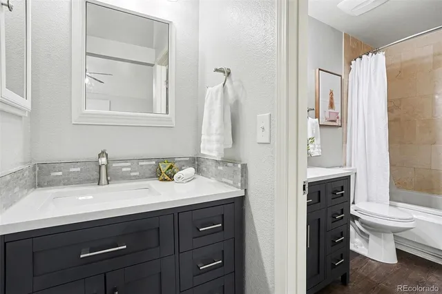 a bathroom with a granite countertop sink toilet and shower